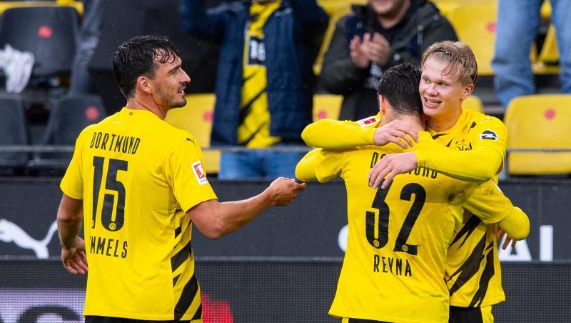 Mats Hummels (l) feiert mit dem Giovanni Reyna (32) umarmenden Erling Haaland einen Treffer im Spiel gegen den SC Freiburg.