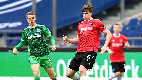 Hannovers Jaka Bijol und Fürths Sebastian Ernst (l) kämpfen um den Ball.