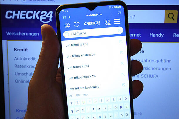 Auf einem Smartphone ist die Website des Preisvergleichsportals Check24 ge&ouml;ffnet. Das Unternehmen hat in der Branche eine enorme Marktmacht und liegt weit vor dem Konkurrenten Verivox.