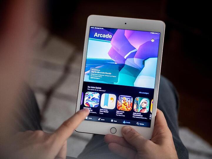 Ein Mann benutzt den Spiele-Abo-Dienst Apple Arcade auf einem iPad.