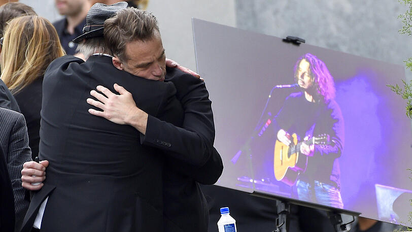 Matt Cameron (rechts) von Soundgarden umarmt einen anderen Gast der Trauerfeier.