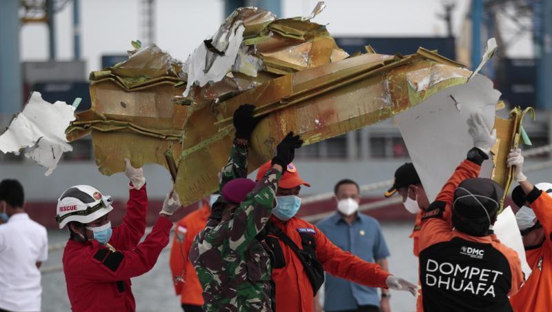 Rettungshelfer tragen ein Teil des Flugzeugs, das aus der Javasee geborgen wurde.