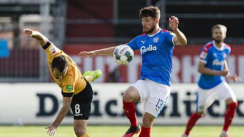 Dresdens Josef Husbauer (l) kommt gegen den Kieler Salih Özcan ins Straucheln.