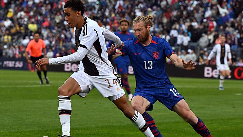 Deutschlands Jamal Musiala und der US-Amerikaner Tim Reamm liefern sich einen Zweikampf um den Ball.