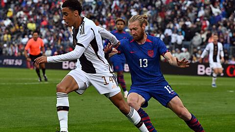 Deutschlands Jamal Musiala und der US-Amerikaner Tim Reamm liefern sich einen Zweikampf um den Ball.