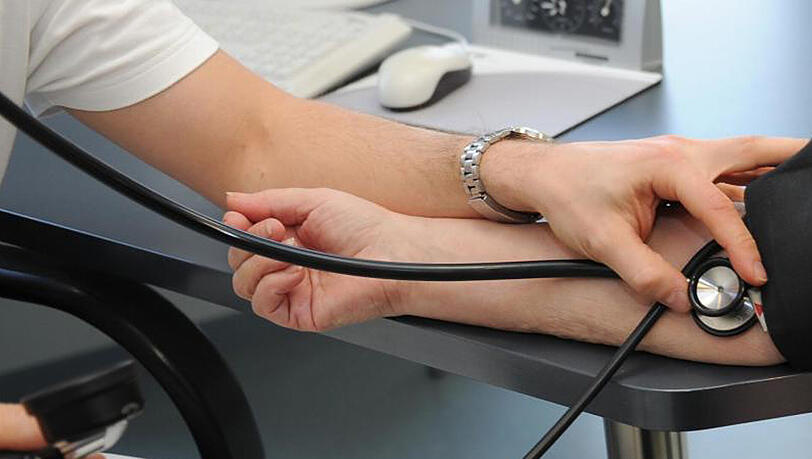 Ein Hausarzt misst bei einer Patientin den Blutdruck. Ein Hausarzt misst bei einer Patientin den Blutdruck.