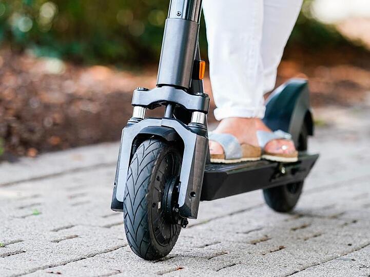 Eine Frau fährt einen E-Scooter. Foto: Uwe Anspach/dpa