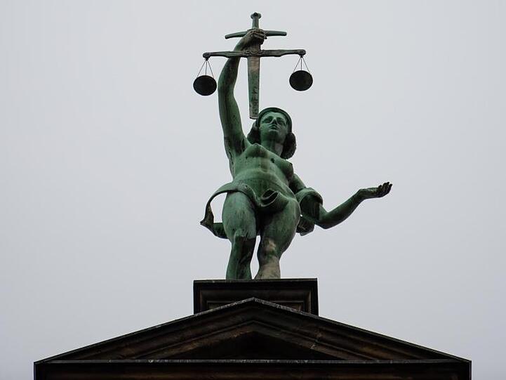 Eine Statue der Justitia ist auf dem Dach des Landgerichtes Bamberg zu sehen. Foto: Nicolas Armer/Archiv