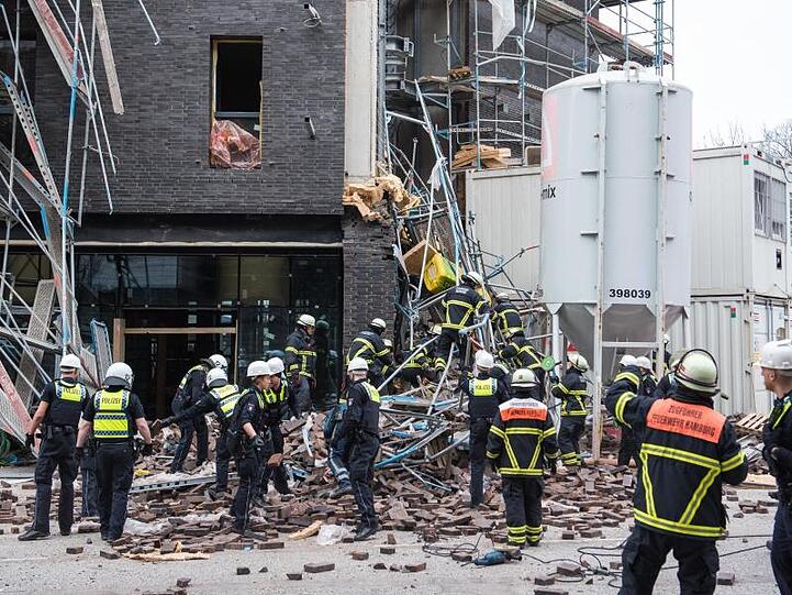 Einsatzkräfte sichern das eingestürzte Gerüst an der Baustelle.