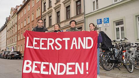 Die Plakataktion der Münchner Linken in der Nacht auf Montag (20.10):  Sie hatten an rund 160 ganz oder teilweise leerstehenden Wohnhäusern in der Stadt Protestplakate gehängt, um damit Leerstand sichtbar zu machen. V.l.: Stadtrat Stefan Jagel und die Aktivisten Antonia Wolf, Christian Schwarzenberger und Anja Fuchsloch – hier vor dem weitgehend leeren Altbau an der Baaderstraße 61.