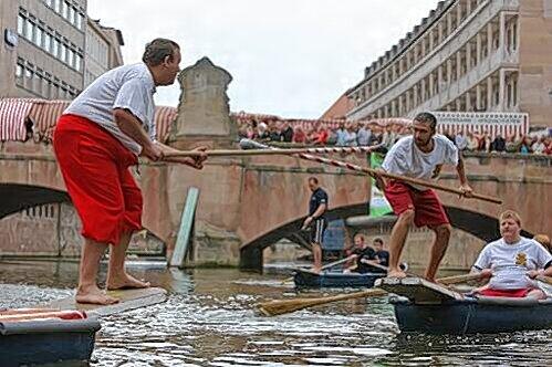 Standhaft auf schwankenden Planken: Die Akteure beim Fischerstechen auf der Pegnitz in der Nürnberger Altstadt.