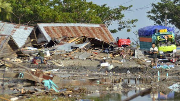 Ein Mann steht inmitten von zerstörten Gebäuden und Schutt, die durch einen Tsunami in Palu, Zentral-Sulawesi, verursacht wurden.