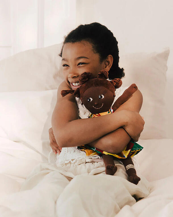 Ein Mädchen mit einer Little Ashé-Puppe. Ein Mädchen mit einer Little Ashé-Puppe.