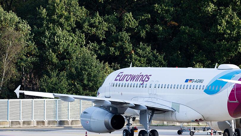 Ein Flugzeug von Eurowings steht am Flughafen.