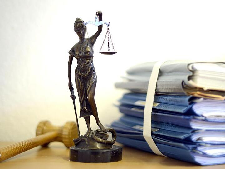 Justitia mit Holzhammer und Aktenstapel. Foto: Volker Hartmann/Archivbild