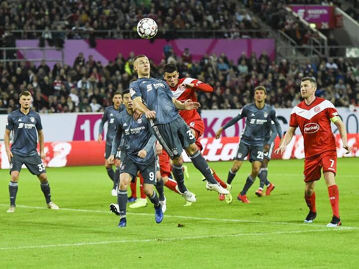 Kopfballduell zwischen Bayerns Joshua Kimmich (vorn) und Düsseldorfs Alfredo Morales. Foto: Christophe Gateau
