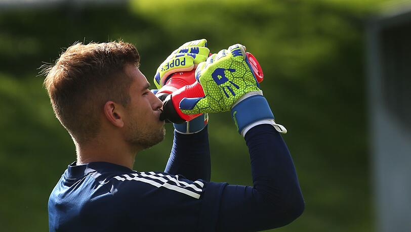 Torwart Julian Pollersbeck trinkt im Training aus zwei Flaschen.