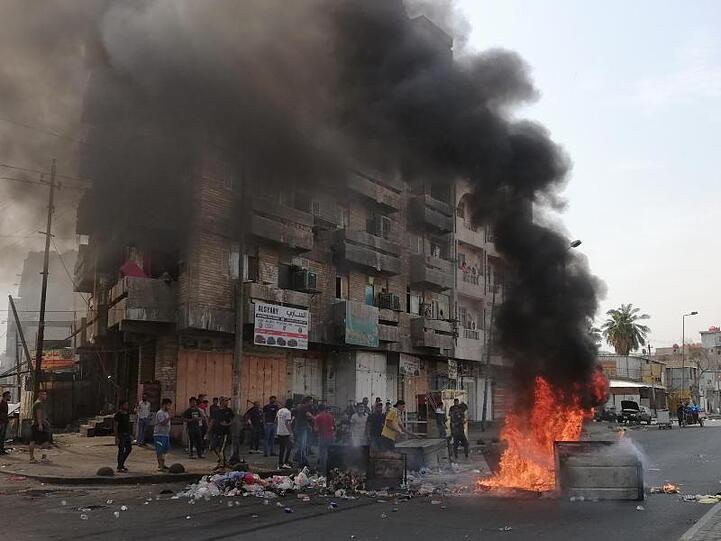 Regierungsgegner haben vor einem Gebäude Straßenblockaden errichtet und ein Feuer entfacht.