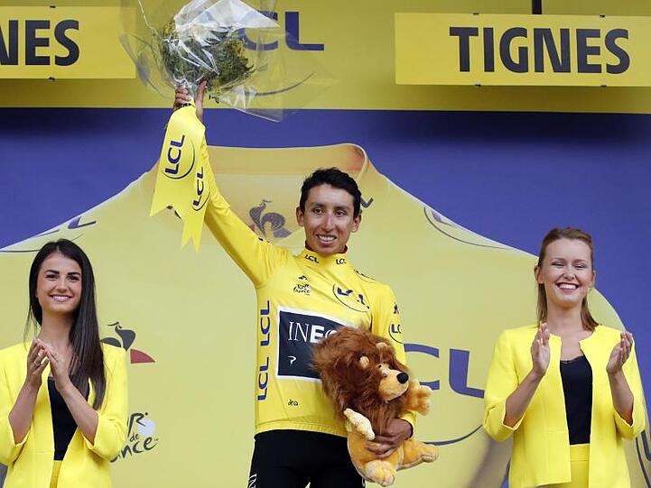Egan Arley Bernal Gomez (M) steht im Gelben Trikot des Gesamtführenden auf dem Podium.