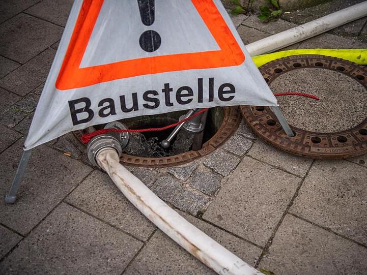 Aus den S-Bahntunneln abgepumptes Wasser fließt in einen vom THW abgesperrten Gullydeckel. Foto: Lino Mirgeler/Archivbild
