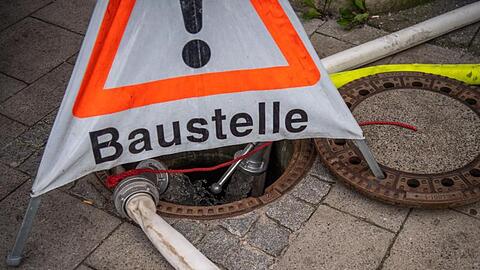 Aus den S-Bahntunneln abgepumptes Wasser fließt in einen vom THW abgesperrten Gullydeckel. Foto: Lino Mirgeler/Archivbild
