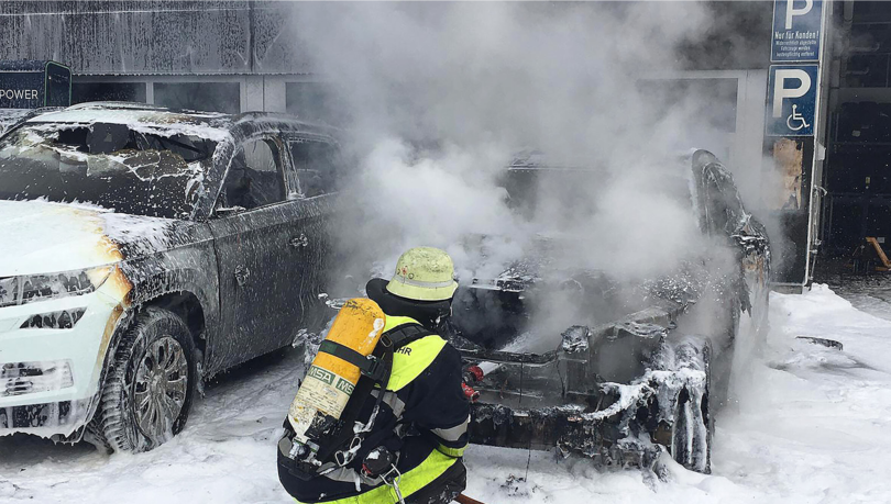 Die Feuerwehr löscht das brennende Elektroauto.