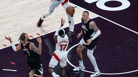 Dennis Schröder (M) kommt zum Wurf, vor ihm Daniel Theis von den Los Angeles Clippers.