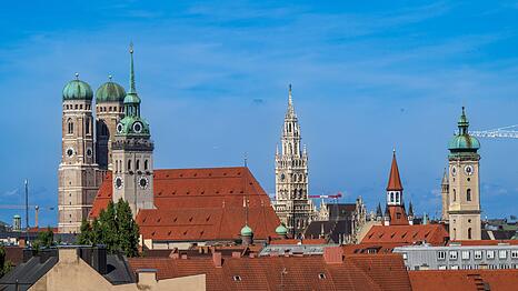 Die Türme der Frauenkirche (l-r), ragen über die Dächer in der Innenstadt.