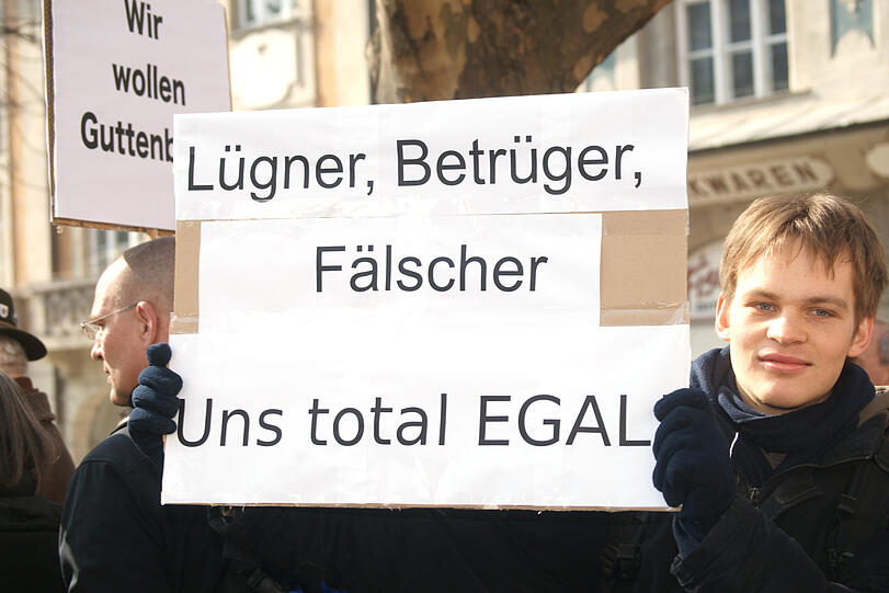 Mal für, mal gegen Karl-Theodor zu Guttenberg, damals noch mit Doktortitel, beziehen die Münchner Anfang März in einer Demo Stellung. Grund für die Empörung sind die kurz zuvor entdeckten Plagiatsstellen in Guttenbergs Dissertation.