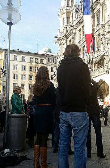Münchnerinnen gedeken der Pariser Opfer vor dem Rathaus.