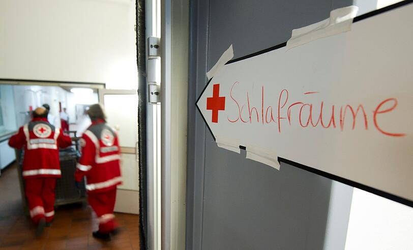 Wohin bloß jetzt für die Nacht? Ein Schild weist den Weg zu den Schlafräumen mit Not-Betten in einer Schule.