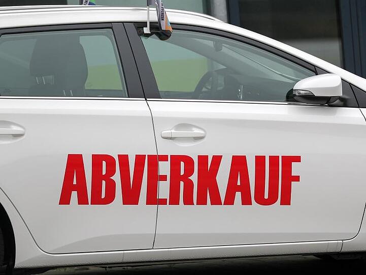 Der Schriftzug "Abverkauf" steht auf einem weißen Toyota vor einem Autohaus.