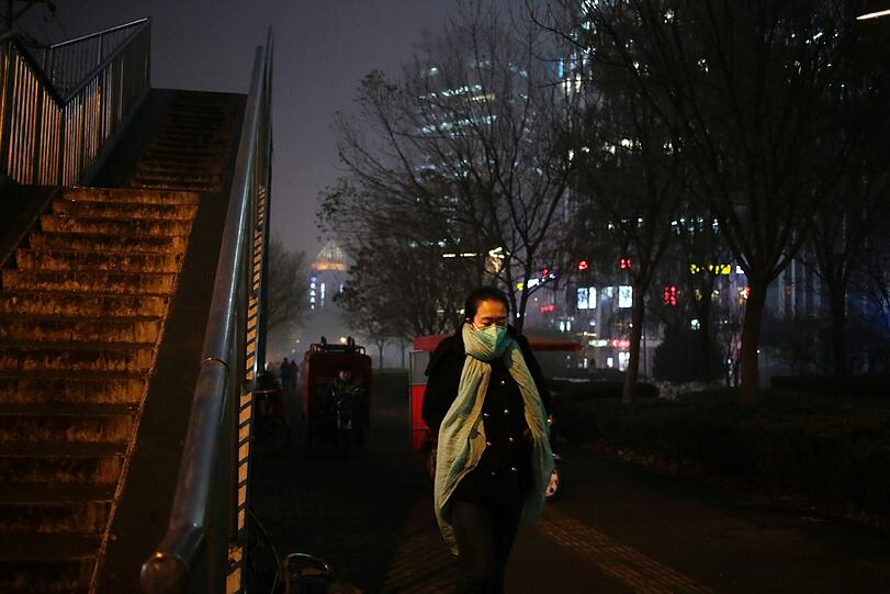Smog in Peking: Eine Frau trägt zum Schutz eine Atemschutzmaske gegen den giftigen Rauch.