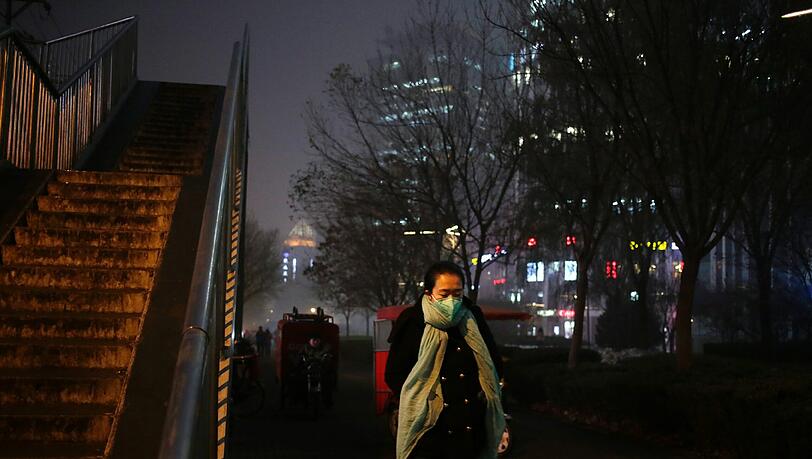 Smog in Peking: Eine Frau trägt zum Schutz eine Atemschutzmaske gegen den giftigen Rauch.