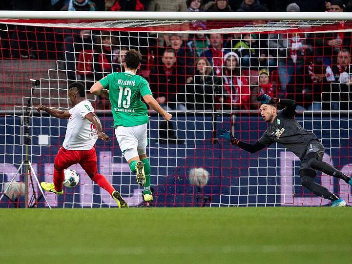 Kölns Jhon Cordoba (l) trifft gegen Bremens Torhüter Jiri Pavlenka (r) zur 1:0 Führung.