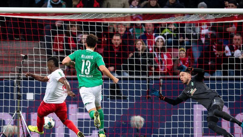 Kölns Jhon Cordoba (l) trifft gegen Bremens Torhüter Jiri Pavlenka (r) zur 1:0 Führung. Kölns Jhon Cordoba (l) trifft gegen Bremens Torhüter Jiri Pavlenka (r) zur 1:0 Führung.