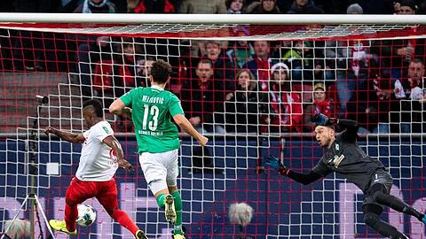 Kölns Jhon Cordoba (l) trifft gegen Bremens Torhüter Jiri Pavlenka (r) zur 1:0 Führung.