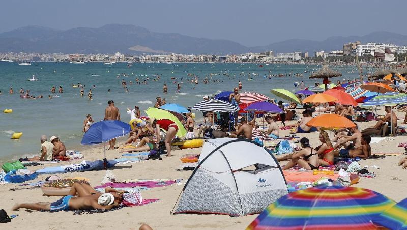 Touristen sonnen sich am Strand von El Arenal, einem der Hauptziele für deutsche und niederländische Touristen während der Sommersaison. Touristen sonnen sich am Strand von El Arenal, einem der Hauptziele für deutsche und niederländische Touristen während der Sommersaison.