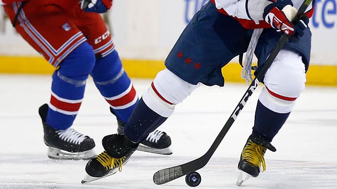Zwei Eishockeyspieler kämpfen um den Puck.