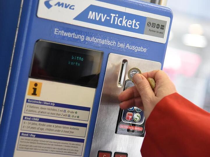 Eine Frau wirft in einer Straßenbahn in München (Bayern) eine Münze in einen Fahrkartenautomat ein. Foto: Amelie Geiger/Archiv