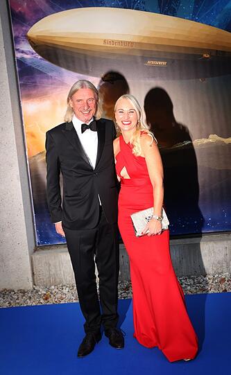 Frank Otto und seine Begleiterin stehen vor der Weltpremiere des Musicals "Zeppelin" auf dem blauen Teppich.