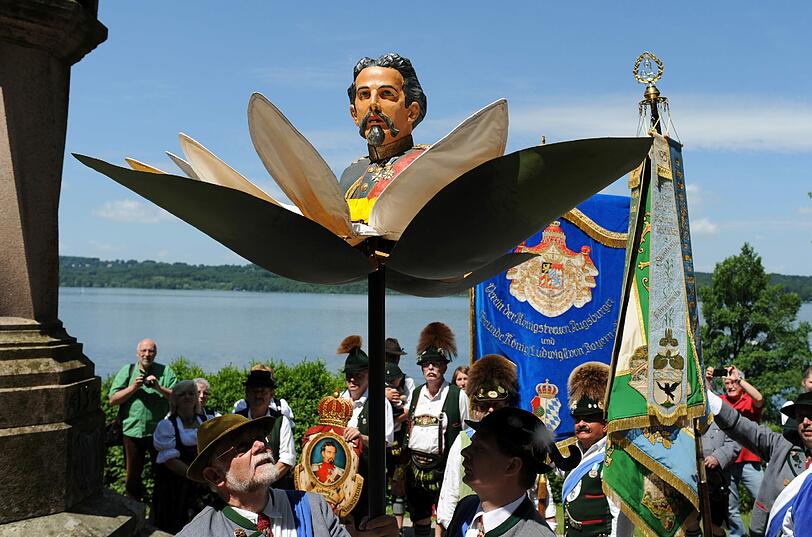 Die Teilnehmer tragen eine bunte Büste des "Märchenkönigs".