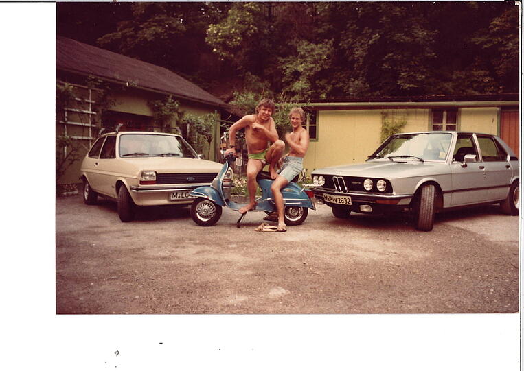 Dietmar Holzapfel (l.) und Sepp Sattler mit blonden Wuschelfrisuren in ihrem ersten Sommer 1978. Rechts steht Sepps damaliger 5-er BMW in Silber, mit dem sie durch Südtirol gekurvt sind. An die goldenen Felgen, die hier leider kaum erkennbar sind, erinnert sich Holzapfel mit ein bissl Grauen.