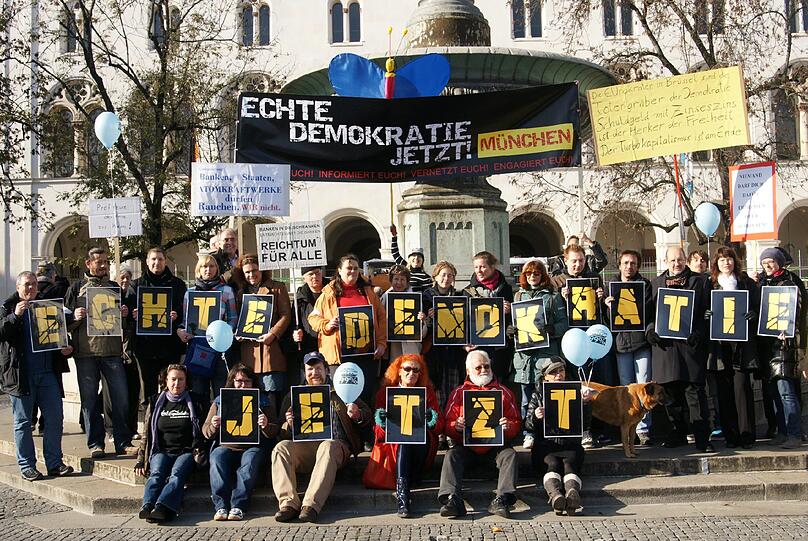 Mit Plakaten gingen rund 300 Menschen in München auf die Straße: Ihr Ziel: mehr Demokratie.