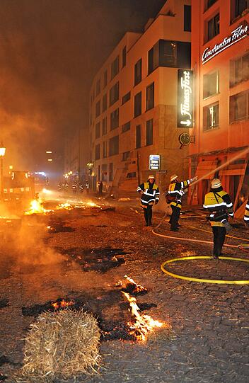 Feuer, Rauch, zerborstene Fenster - nach der Sprengung der Bombe hat die Feuerwehr viel zu tun: Umherfliegendes Stroh hatte Brände verursacht.