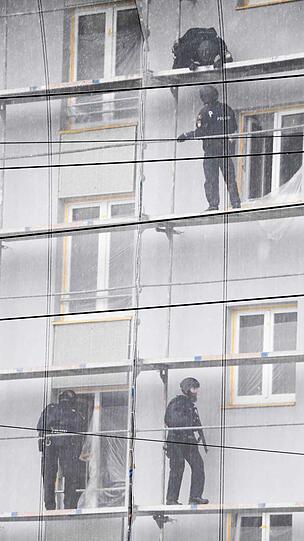 Die Polizei auf dem Gerüst des Hauses. Der Verdächtige hatte sich in eine Wohnung zurückgezogen.