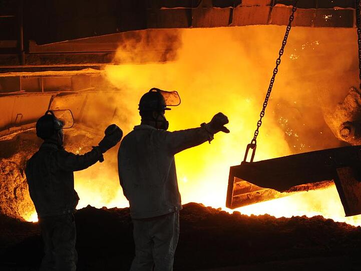 Stahlarbeiter arbeiten vor einem angestochenen Hochofen in dem staatlichen Unternehmen "Dongbei Special Steel".