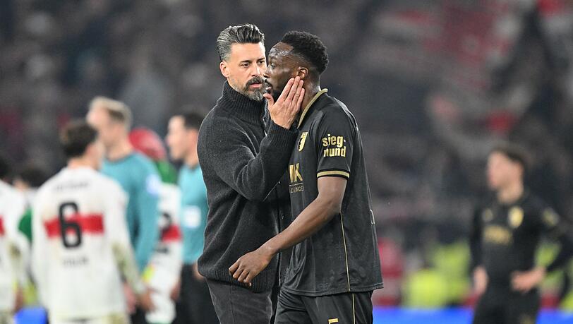 Wieder nichts: Augsburgs Trainer Wagner versucht den Verteidiger Matsima zu trösten. Wieder nichts: Augsburgs Trainer Wagner versucht den Verteidiger Matsima zu trösten.