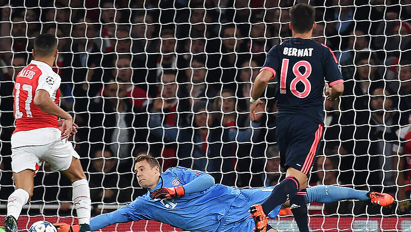 Bayern-Keeper Manuel Neuer rettet nach einem Schuss von Arsenal-Profi Theo Walcott (nicht im Bild) - links Alexis Sanchez, rechts Juan Bernat. Bayern-Keeper Manuel Neuer rettet nach einem Schuss von Arsenal-Profi Theo Walcott (nicht im Bild) - links Alexis Sanchez, rechts Juan Bernat.