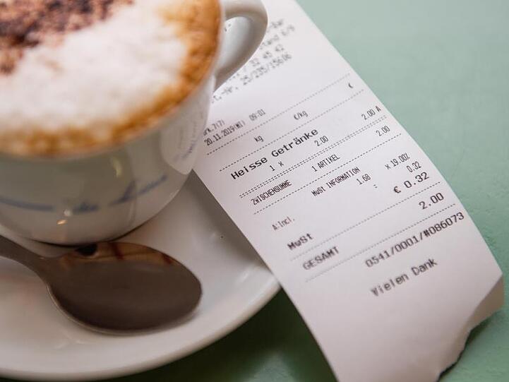 In einem Café liegt neben einer Tasse eine Quittung.